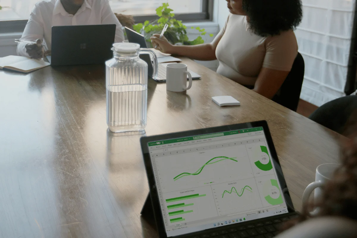 Team reviewing data analytics on laptop during office meeting.