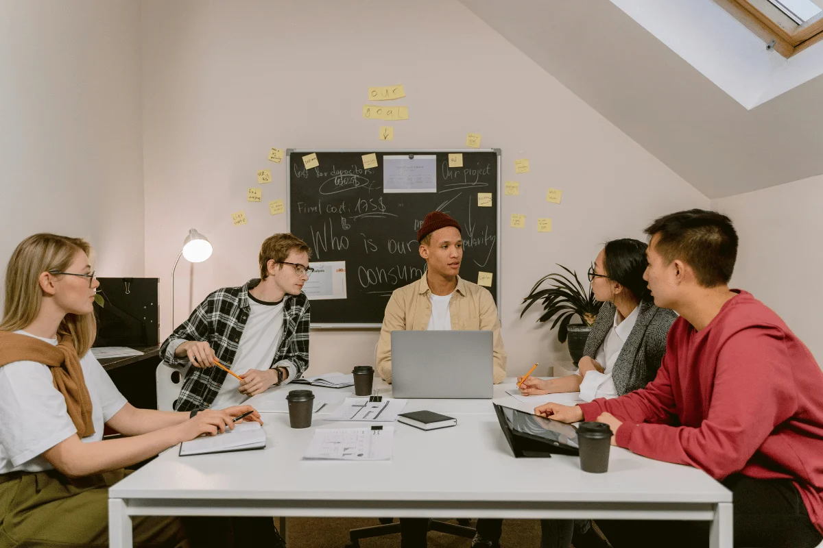 Collaborative workspace with documents and laptop.