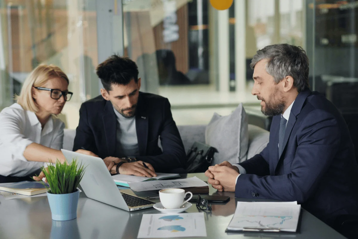 Business professionals analyzing data dashboards on a laptop.