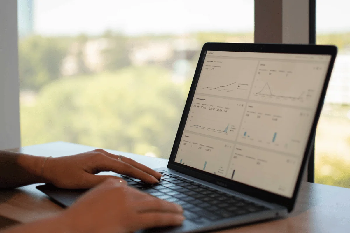 Person analyzing business analytics dashboard on laptop screen.