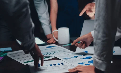 Business team analyzing data charts during a meeting.