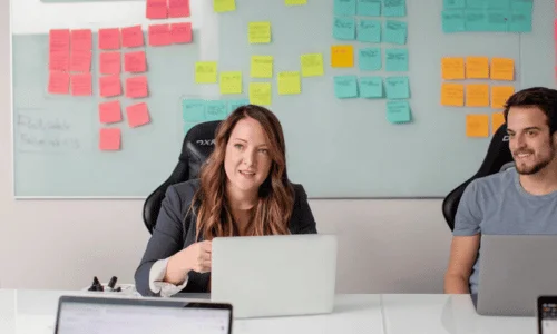 Business team collaborating during strategy meeting with colorful sticky notes.