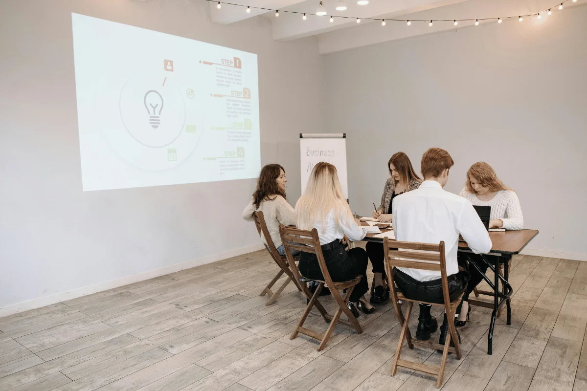 Group of young professionals brainstorming around a table in a meeting room.