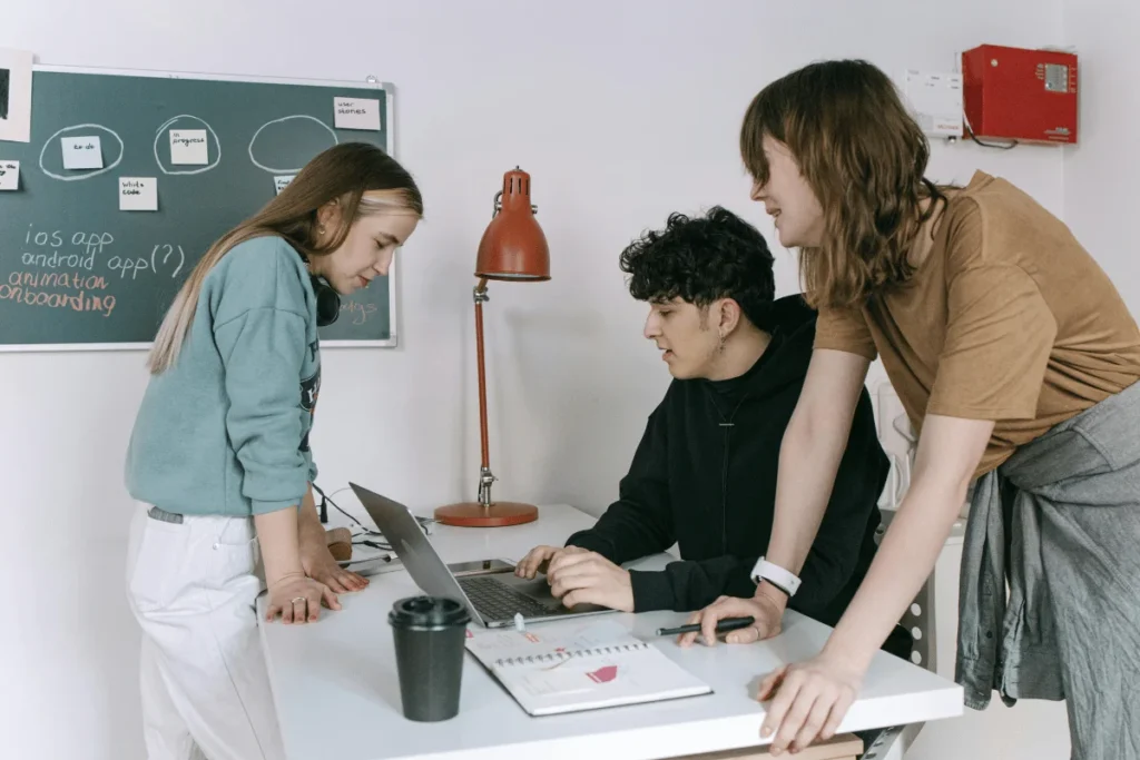 Group of young professionals working on a project at a desk.