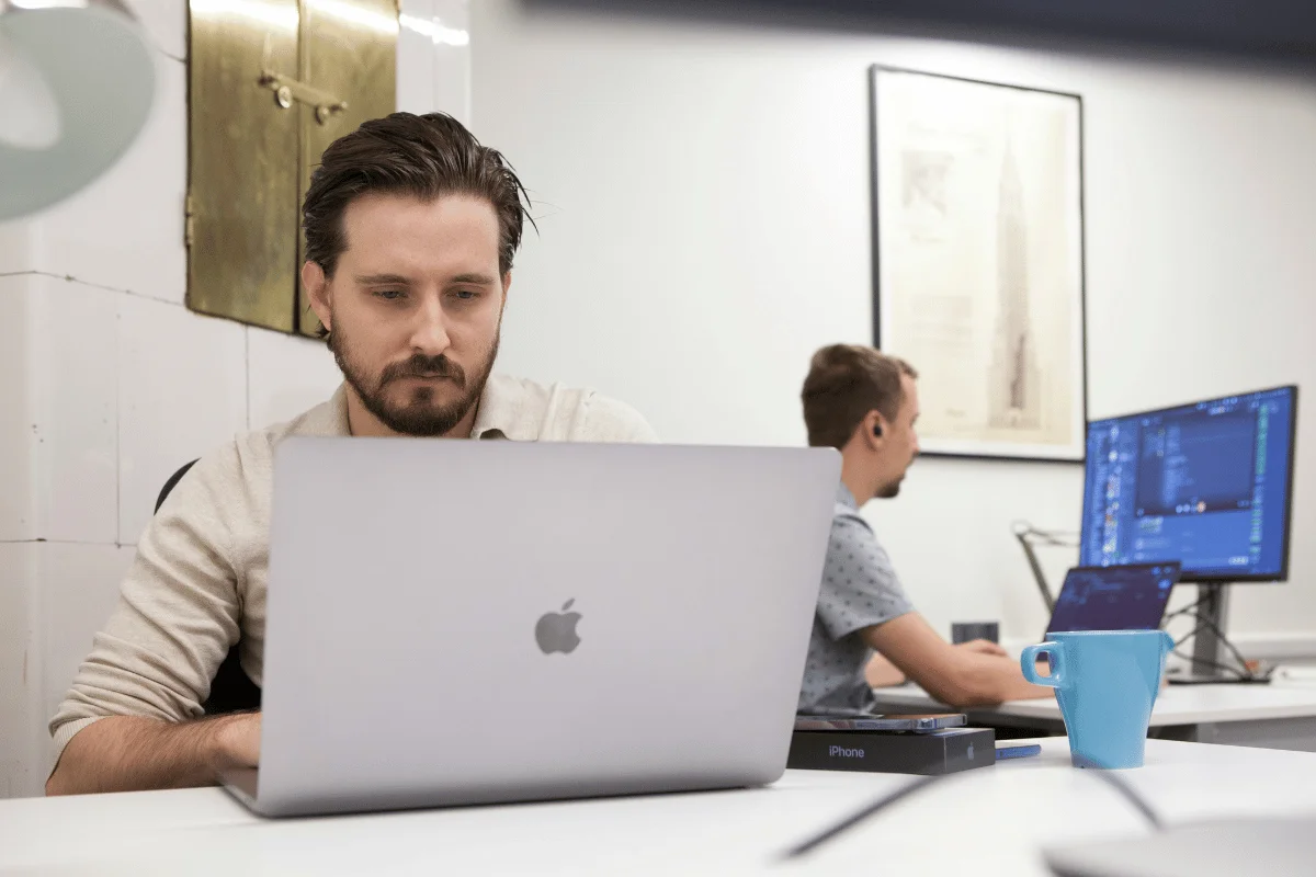 Focused man working on a MacBook in a modern office.
